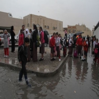 اطفال في شارع ملئ بمياة الامطار